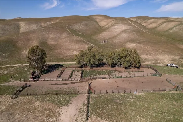 a view of a dry yard with wooden fence