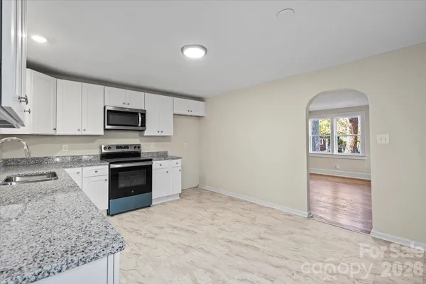 a kitchen with granite countertop a stove top oven and sink