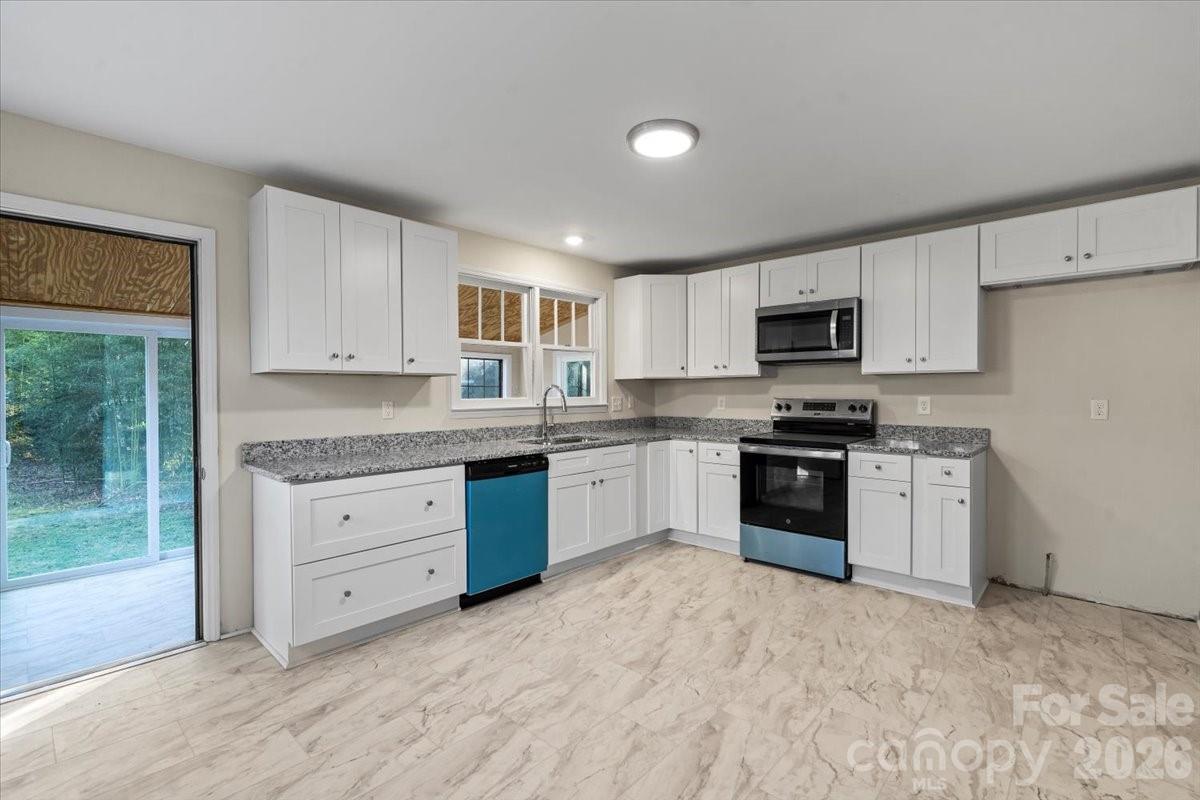 165 East Lacy Street Chester, SC 29706 - Photo 6 of 16 a kitchen with granite countertop white cabinets and stainless steel appliances