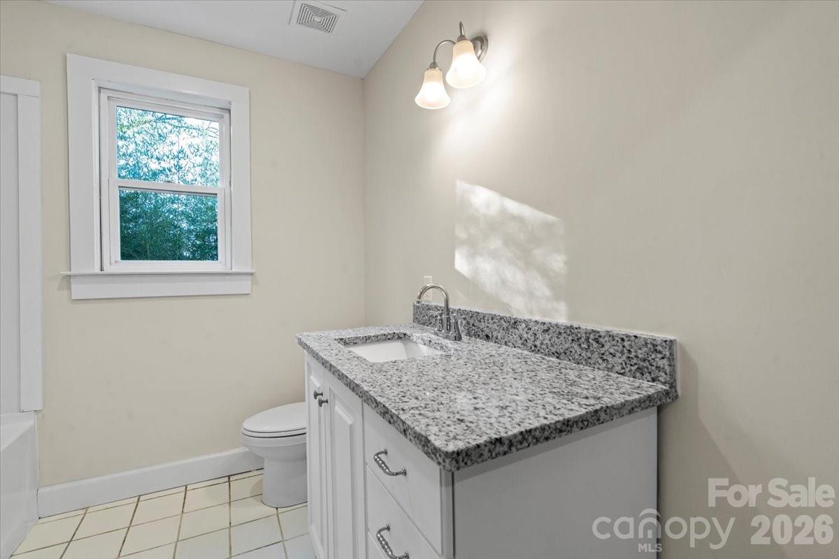 165 East Lacy Street Chester, SC 29706 - Photo 9 of 16 a bathroom with a granite countertop sink and a toilet