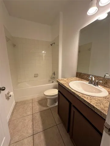 a bathroom with a granite countertop sink a toilet a mirror and shower