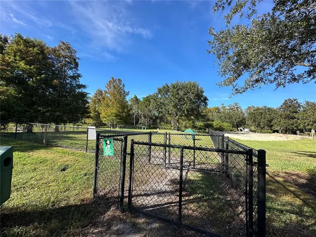 a view of swimming pool with seating space and trees in the background