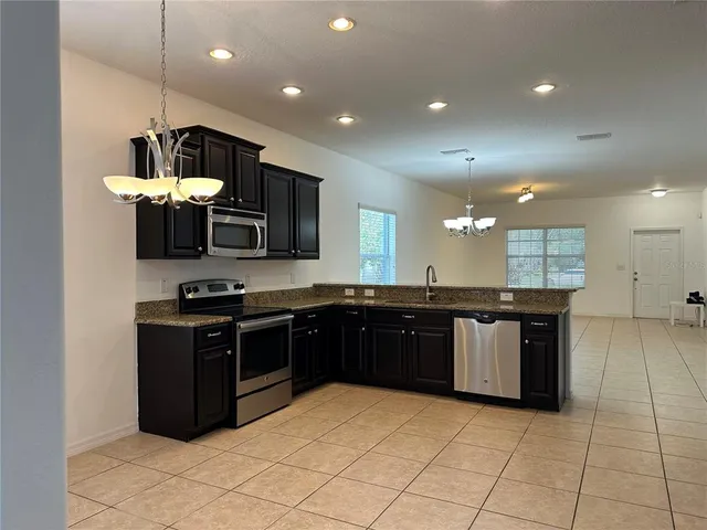 a kitchen with stainless steel appliances granite countertop a stove and a sink