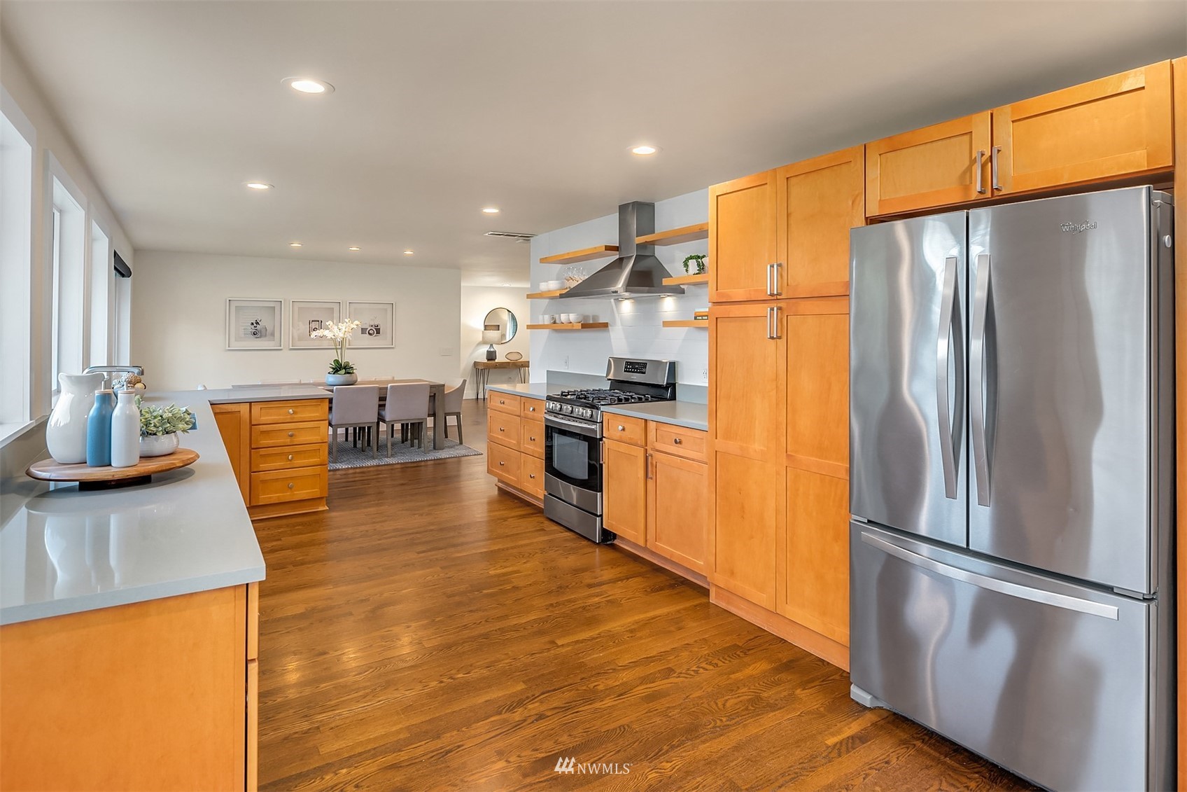 14217 Southeast 144th Street Renton, WA 98059 - Photo 10 of 30 a kitchen with stainless steel appliances granite countertop a refrigerator a stove and a sink with wooden floor