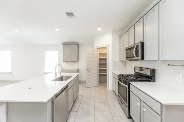 a kitchen that has a sink and a stove top oven