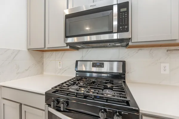 a stove top oven sitting inside of a kitchen