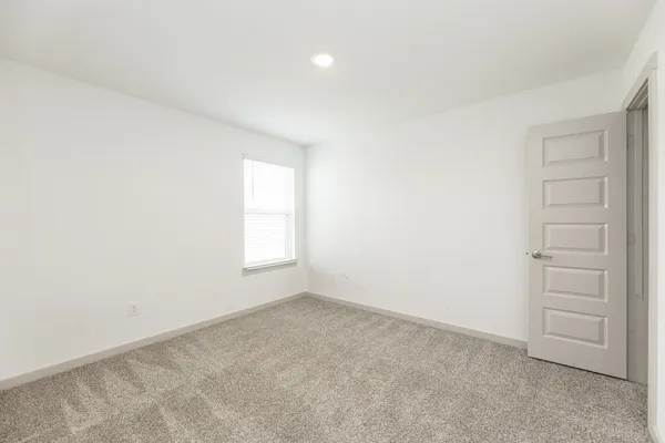 an empty room with windows and cabinet