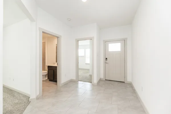 a view of an empty room with window and bathroom