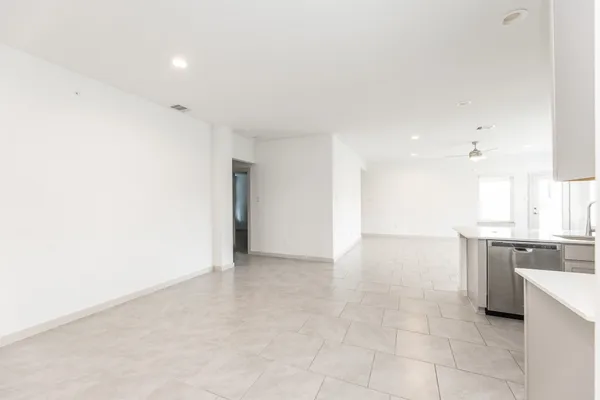 a view of kitchen with granite countertop cabinets and refrigerator
