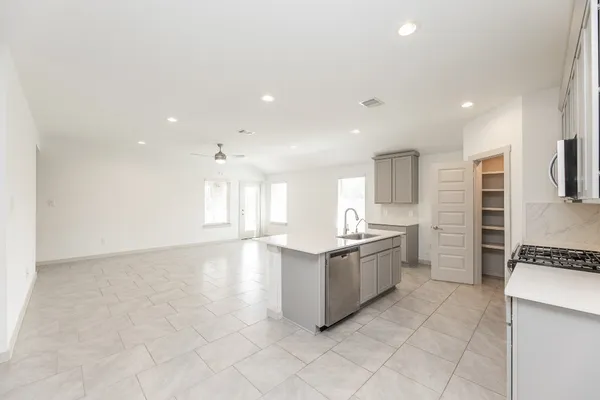 a large kitchen with a stove a sink and a refrigerator