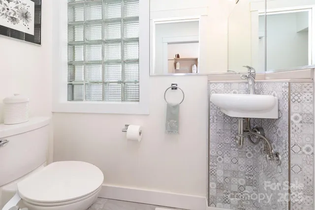 a white toilet sitting next to a bathroom sink