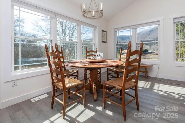 a dining room with furniture a chandelier and wooden floor