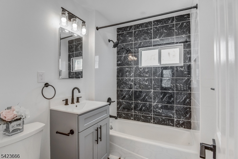 1017 Grandview Avenue Union, NJ 07083 - Photo 19 of 34 a bathroom with a bathtub sink vanity and mirror