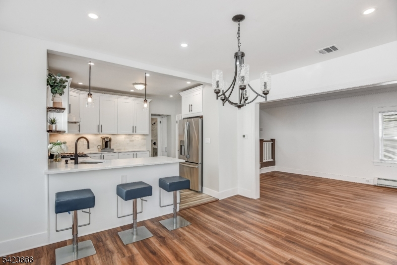 1017 Grandview Avenue Union, NJ 07083 - Photo 22 of 34 a kitchen with stainless steel appliances a dining table chairs refrigerator and cabinets