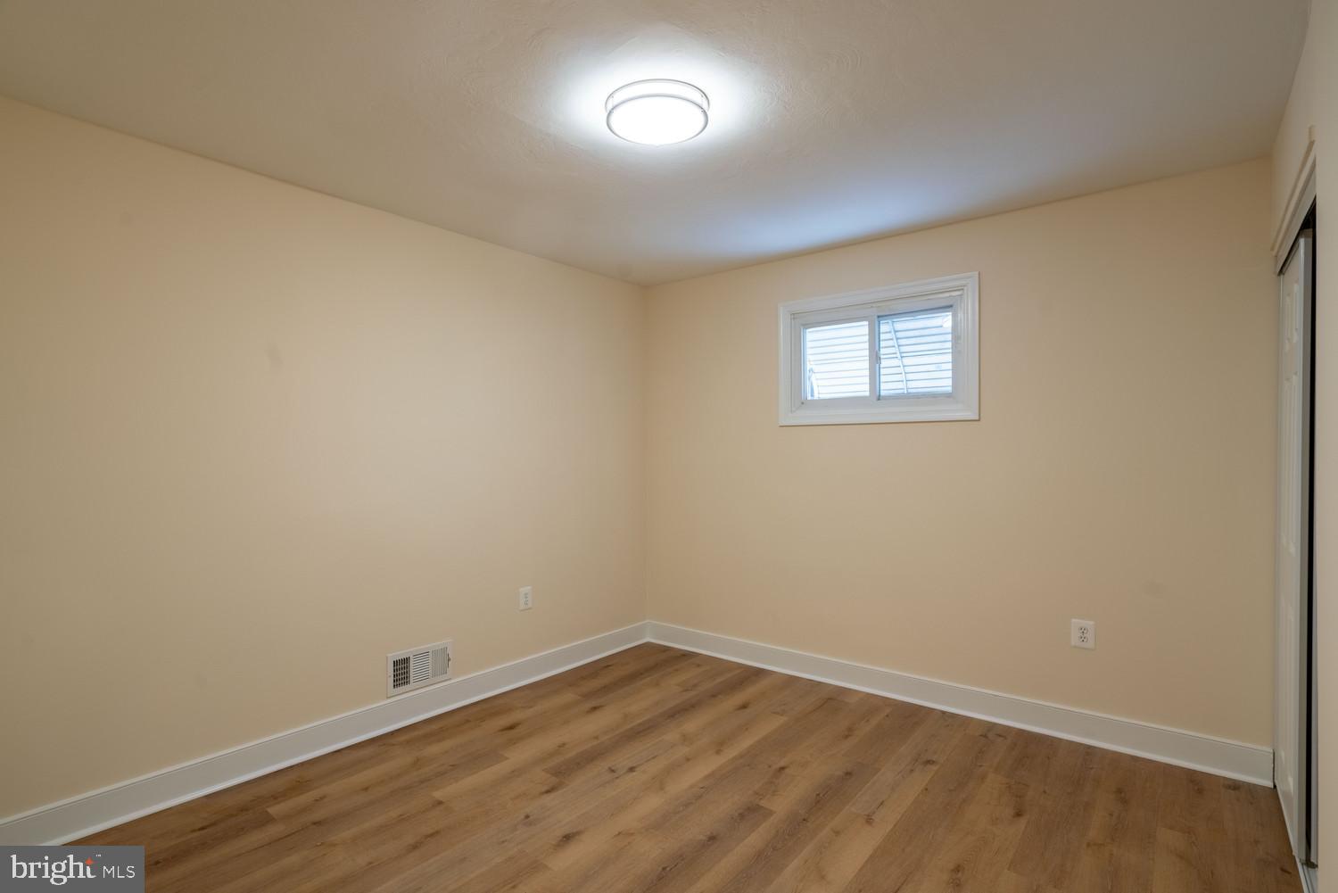 7313 Dooman Road Baltimore, MD 21244 - Photo 21 of 35 an empty room with wooden floor and windows
