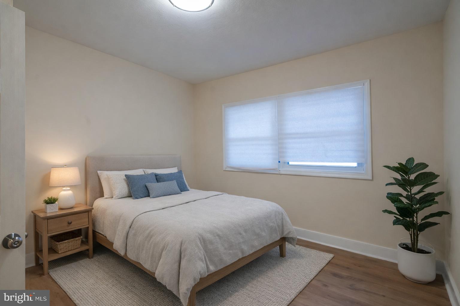 7313 Dooman Road Baltimore, MD 21244 - Photo 32 of 35 a bedroom with a bed and a potted plant