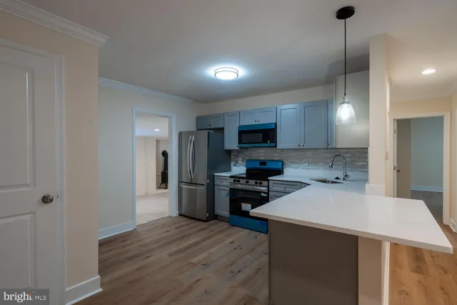 a kitchen with kitchen island a sink stainless steel appliances and cabinets