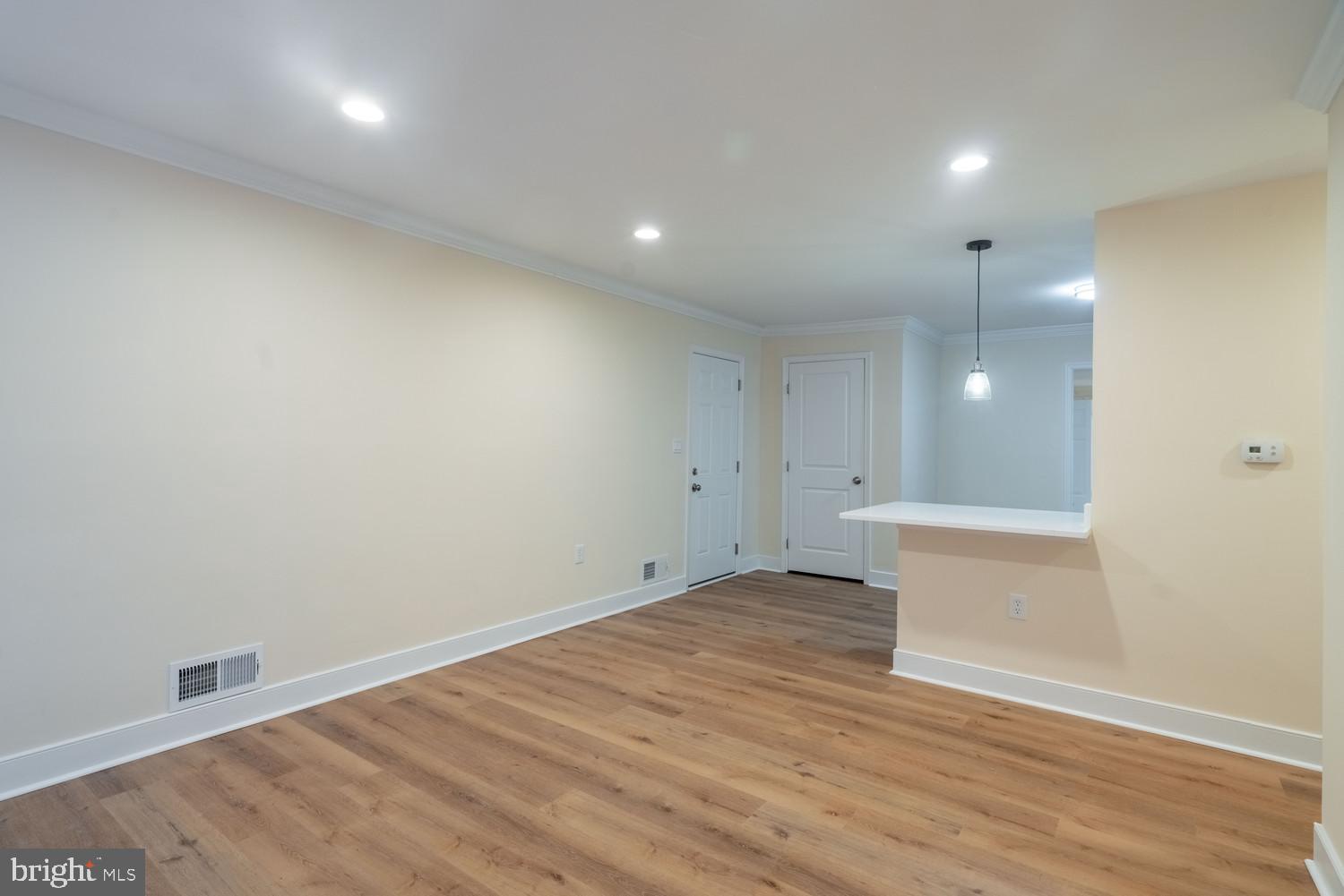 7313 Dooman Road Baltimore, MD 21244 - Photo 10 of 35 an empty room with wooden floor and windows