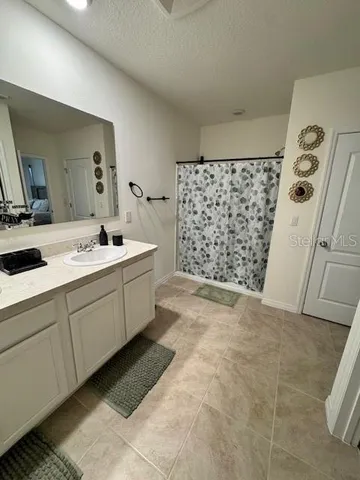 a kitchen with white cabinets and refrigerator