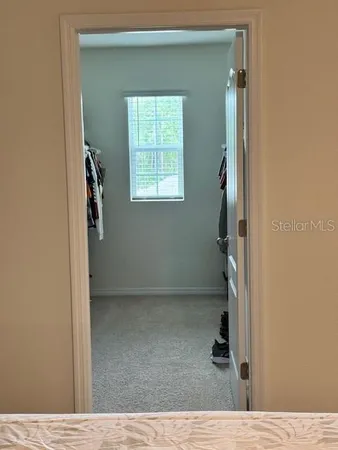 a view of walk in closet with clothes and shoes