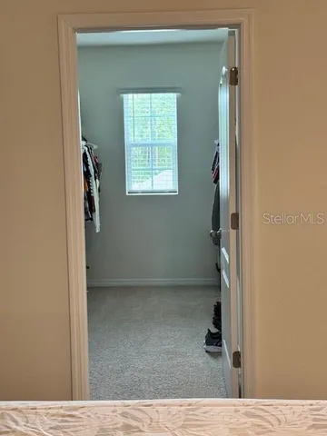a view of walk in closet with clothes and shoes