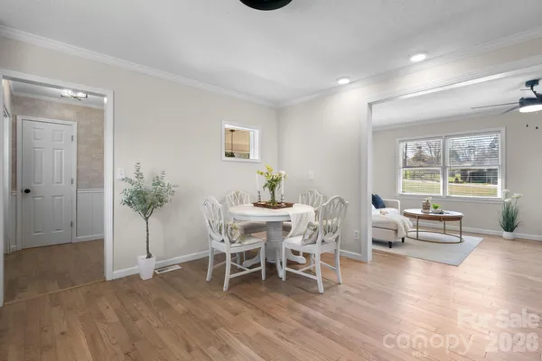 a dining room with furniture potted plants and wooden floor