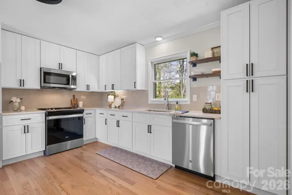 a kitchen with granite countertop a refrigerator stove top oven and sink