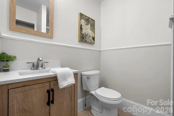 a bathroom with a toilet sink vanity and mirror