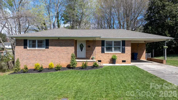 a view of a house with a yard and sitting area