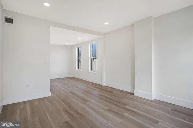 a view of an empty room with wooden floor