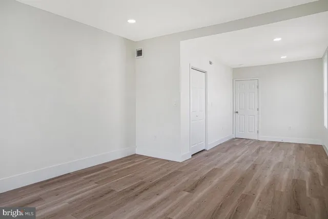 a view of an empty room with wooden floor