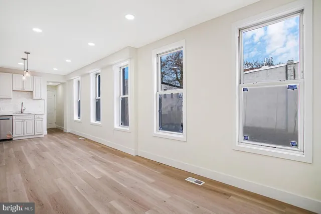 a view of a big room with wooden floor and windows