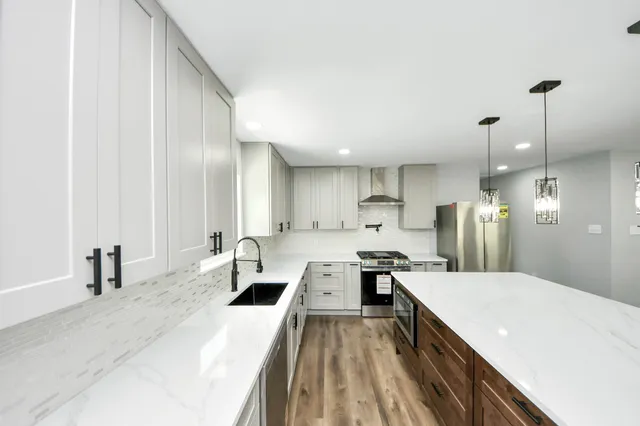 a view of kitchen with stainless steel appliances granite countertop a stove and a refrigerator