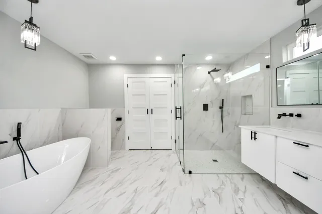 a bathroom with a glass shower door a sink and a mirror