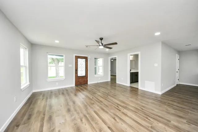 a large kitchen with kitchen island a sink dishwasher a stove and a refrigerator with wooden floor