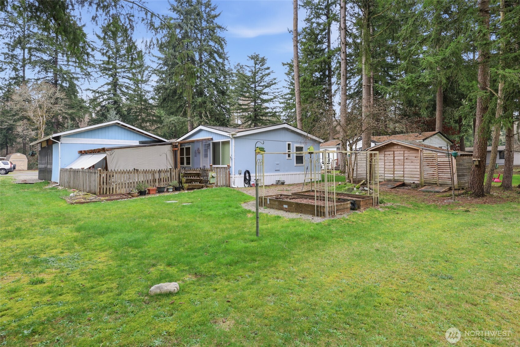 17340 Sargent Road Southwest, Unit 54 Rochester, WA 98579 - Photo 21 of 30 a view of a house with a yard and sitting area