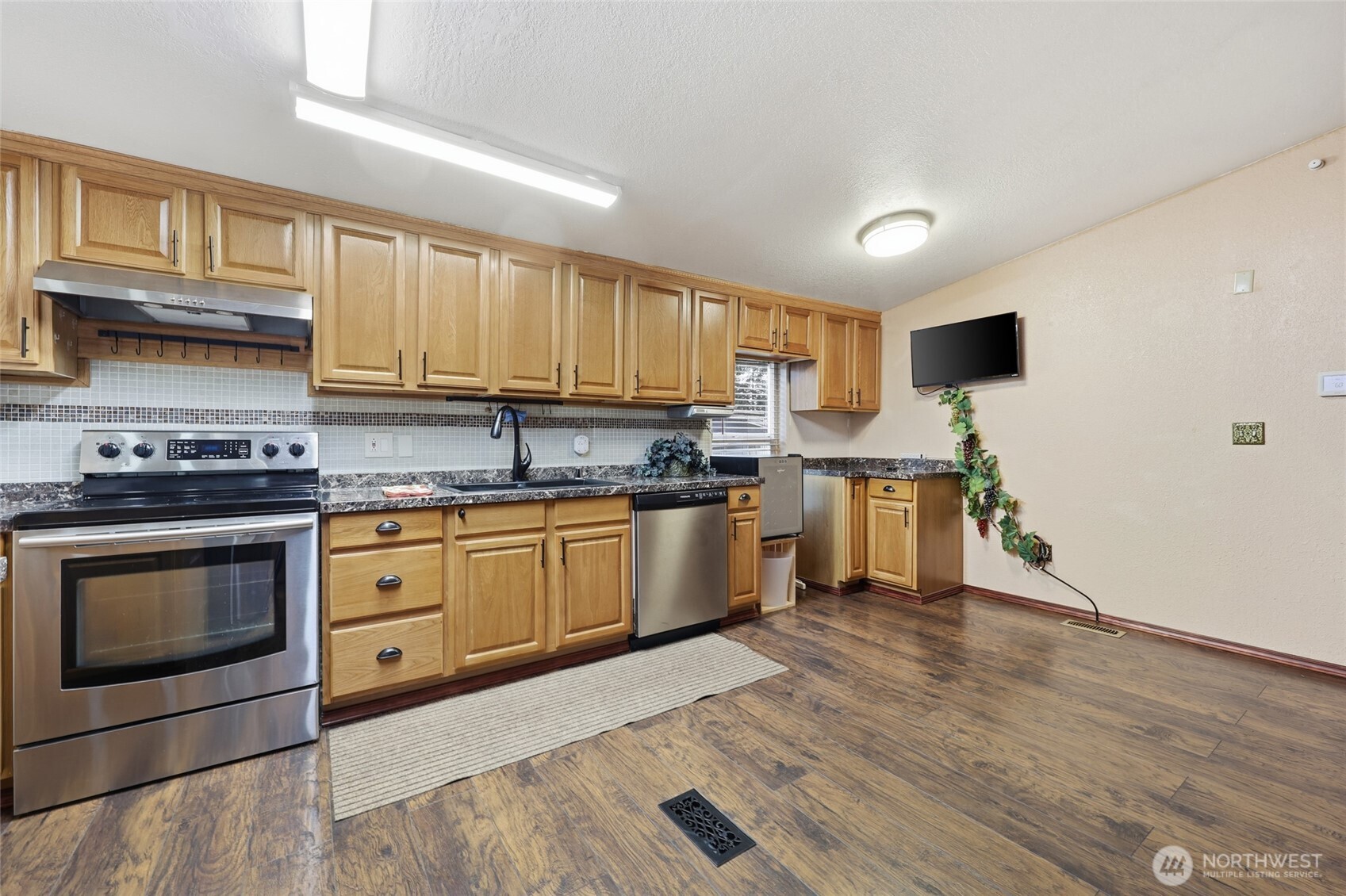 17340 Sargent Road Southwest, Unit 54 Rochester, WA 98579 - Photo 3 of 30 a kitchen with stainless steel appliances granite countertop a stove sink and cabinets