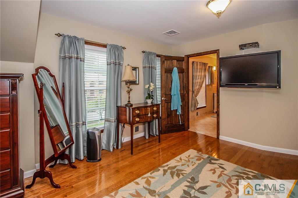48 Harding Avenue Edison, NJ 08820 - Photo 14 of 25 a bedroom with furniture and a flat screen tv