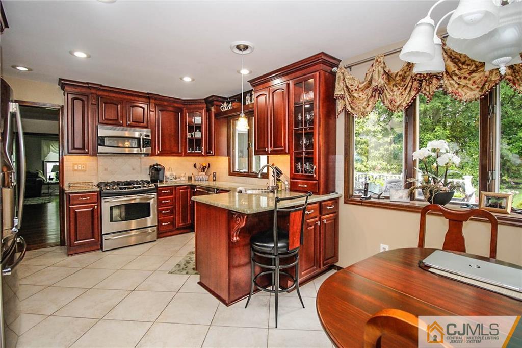48 Harding Avenue Edison, NJ 08820 - Photo 8 of 25 a kitchen with stainless steel appliances granite countertop a stove a sink dishwasher and a refrigerator with wooden floor