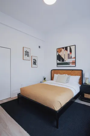 a bedroom with a bed and painting on the wall