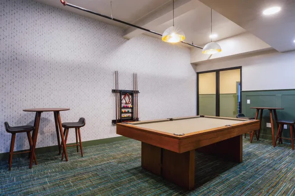 a room with pool table and windows