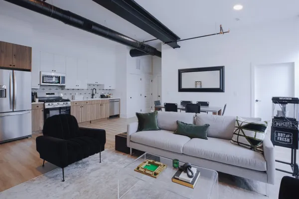 a living room with furniture and a refrigerator
