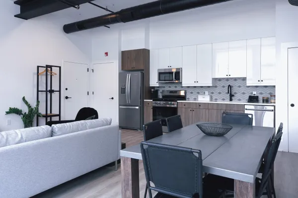 a kitchen with a table chairs refrigerator and microwave