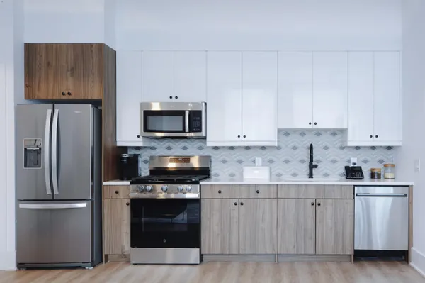 a kitchen with white cabinets and stainless steel appliances