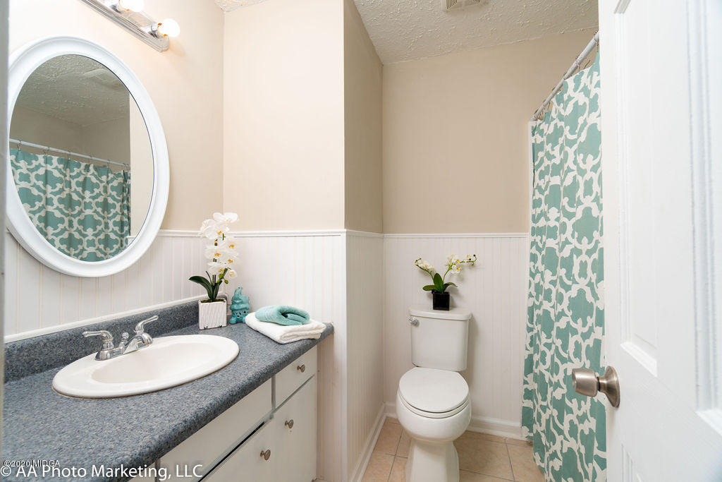 175 Red Oak Road Byron, GA 31008 - Photo 22 of 42 a bathroom with a granite countertop toilet a sink and a mirror