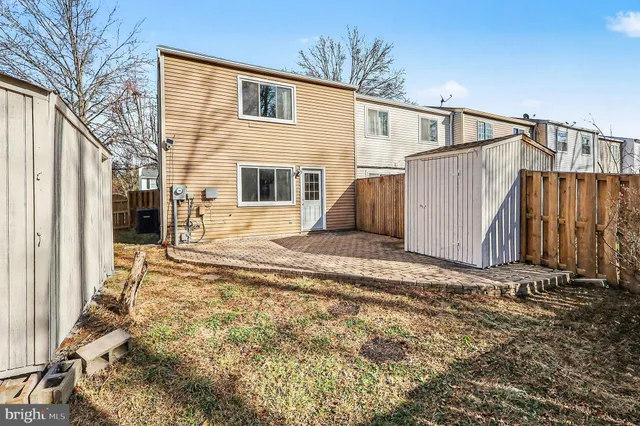 a view of a house with backyard and wooden fence