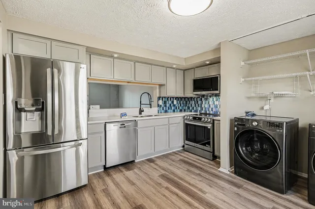 a kitchen with a refrigerator sink and cabinets