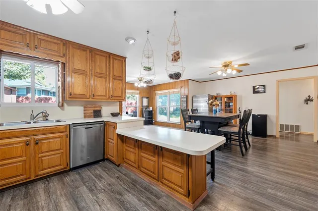 a kitchen with kitchen island granite countertop wooden floors and a view of living room