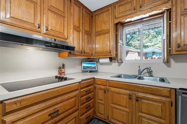 a kitchen with stainless steel appliances granite countertop a sink a stove and cabinets