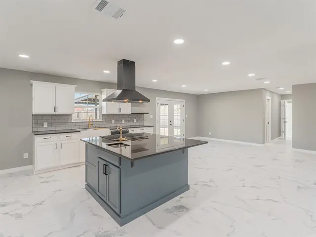 an empty room with windows and ceiling fan